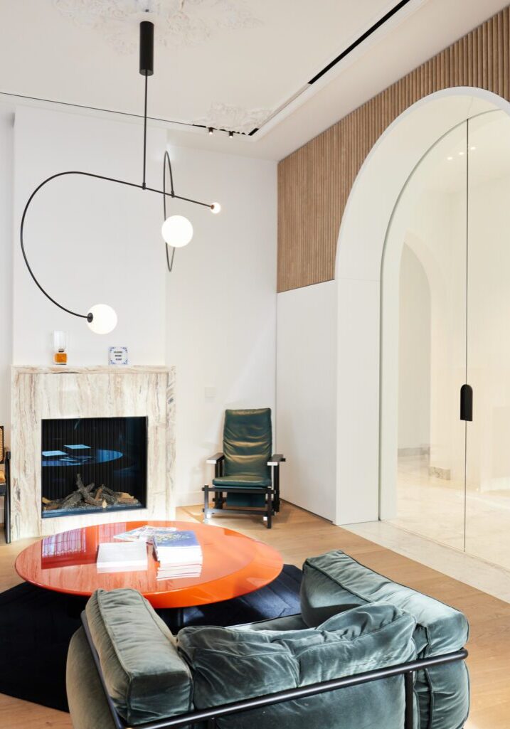 Ontvangstruimte met haard, glazen boogwand, ribbelwand en hoge plafonds, kantoorinterieur Apeldoorn