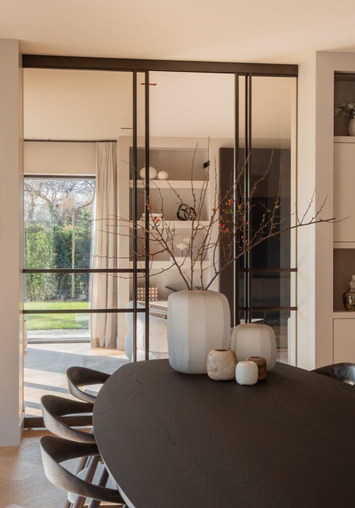Maatwerk wandkasten aan weerszijden van stalen kozijnen, eethoek villa Laren