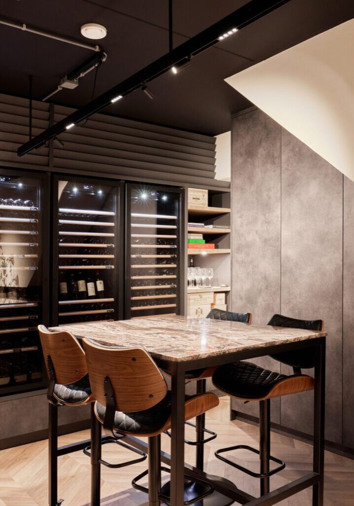 Maatwerk wijnkamer met ingebouwde wijnkoelers, marmeren proeftafel en betonlook kastenwand — ontwerp en realisatie Mint Interieur